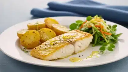 Filet de poisson doré à la poêle, accompagné de pommes de terre rôties et d’une salade croquante de jeunes pousses et légumes frais.