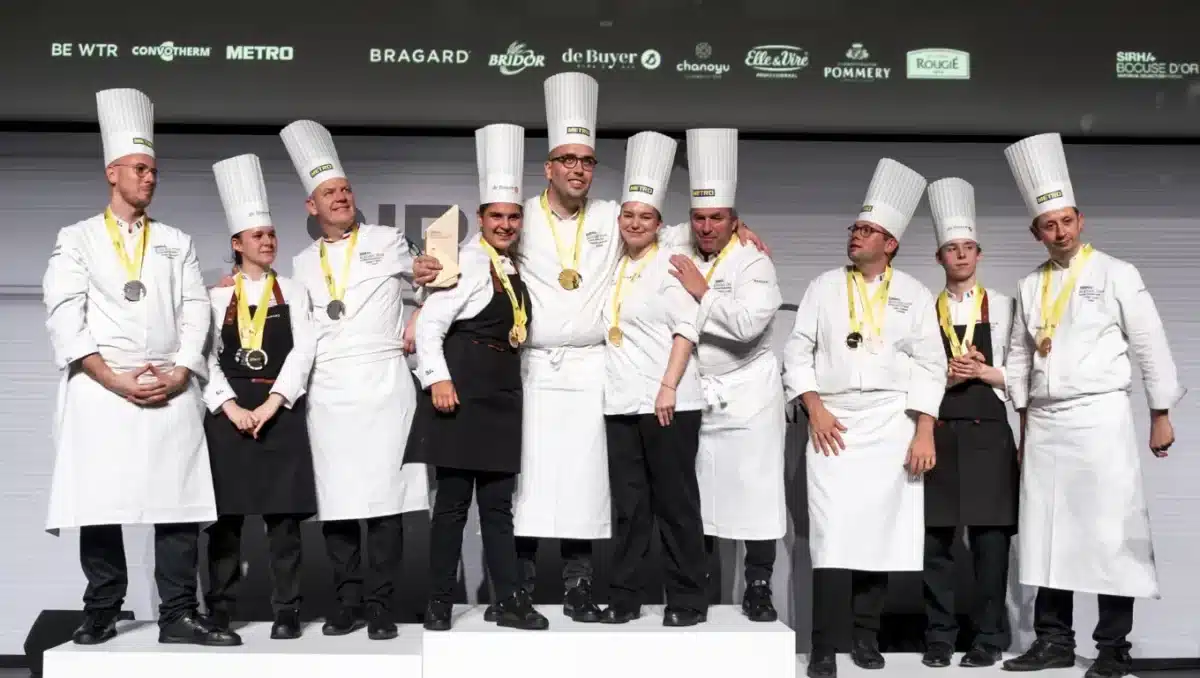 Assiette gastronomique dressée avec élégance lors du Bocuse d’Or France 2025, avec un chef souriant en arrière-plan.