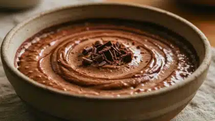 Bol de riz au lait au chocolat crémeux surmonté de copeaux de chocolat noir, dessert réconfortant et gourmand.