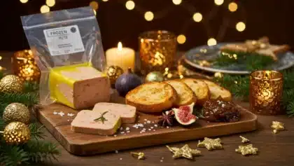 Foie gras sous vide sur planche en bois avec pain grillé et décor de fêtes, prêt à être congelé pour Noël.