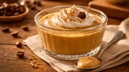 Une crème dessert onctueuse au café, servie dans un ramequin en verre avec chantilly et grain de café.