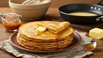 Pile de crêpes maison dorées et moelleuses, nappées de sirop et servies avec du beurre, prêtes à être dégustées
