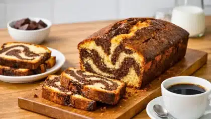 Cake marbré maison moelleux au chocolat et à la vanille tranché sur une planche avec café