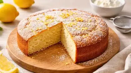 Gâteau à la ricotta et au citron moelleux saupoudré de sucre glace avec une part coupée