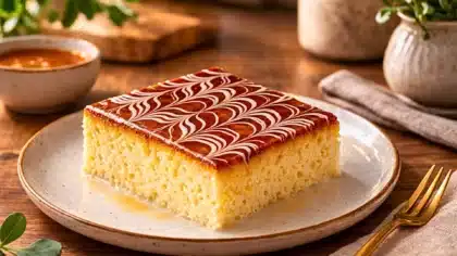 Part de gâteau trileçe imbibé aux trois laits avec nappage caramel décoré de motifs blancs